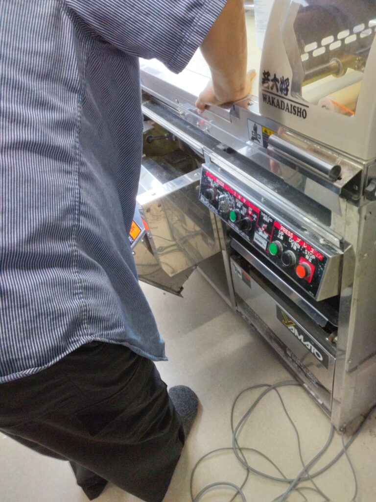 製麺機を拭いている