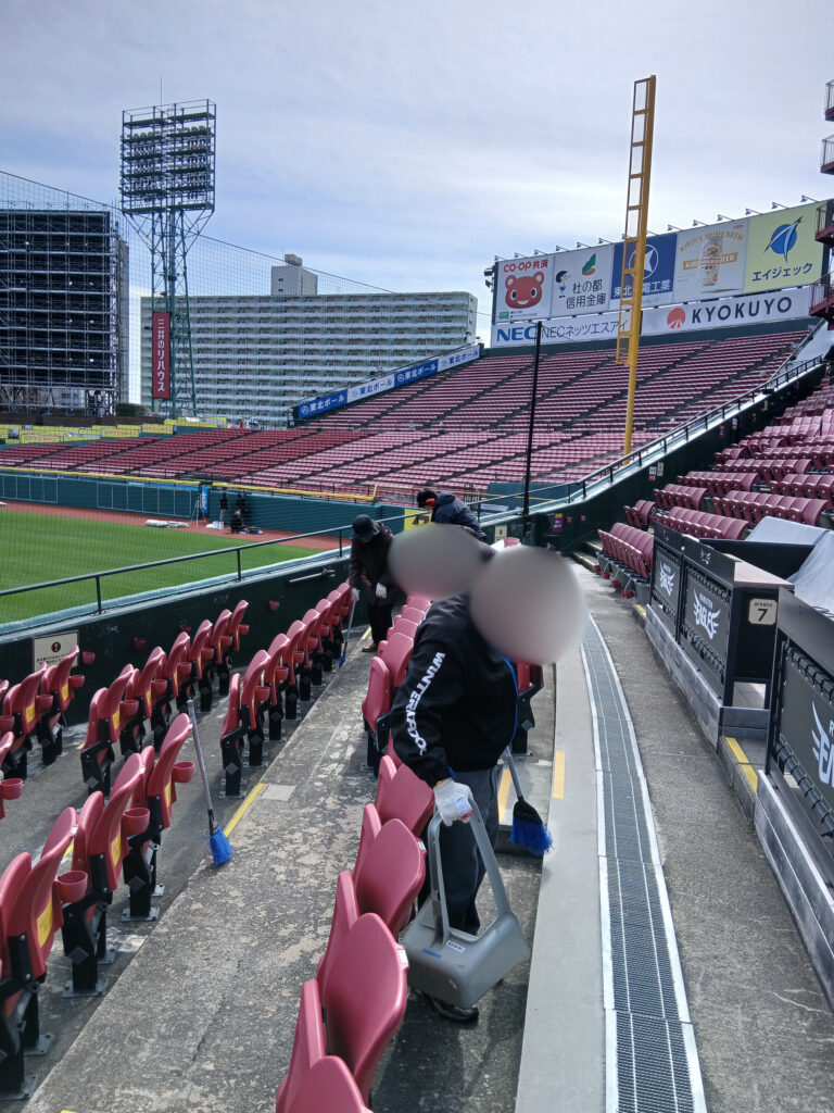 階段に気をつけながら掃き掃除をしている写真