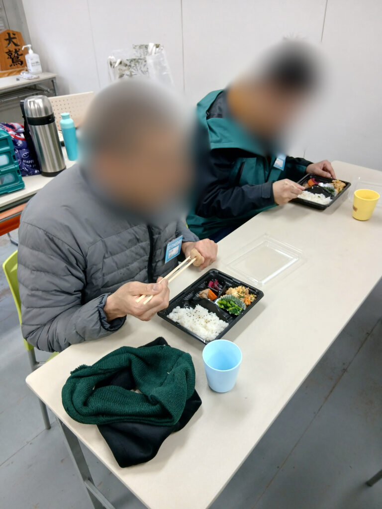 お弁当を食べる男性二人の写真