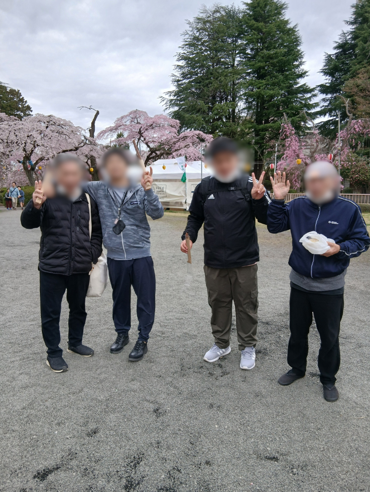 屋台の食べ物を持ち笑顔の利用者さんたちの写真